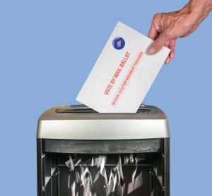 Vote by mail or absentee ballot being shredded in office paper shredder as illustration of voting fraud or lost votes in Presidential election